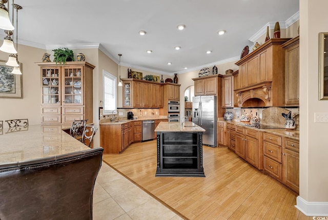 kitchen with backsplash, an island with sink, appliances with stainless steel finishes, and light stone counters