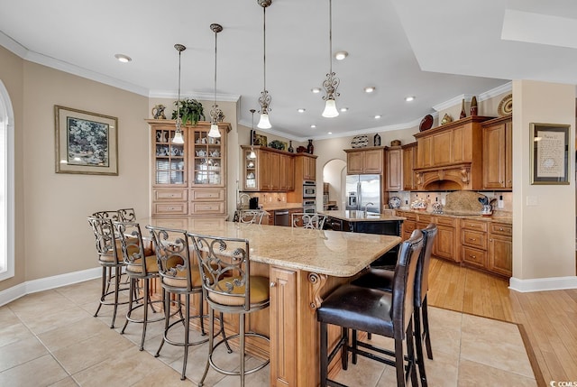 kitchen with hanging light fixtures, tasteful backsplash, a large island, and a breakfast bar