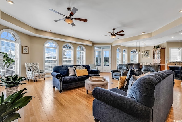 living room with french doors, wine cooler, ceiling fan, and light hardwood / wood-style flooring