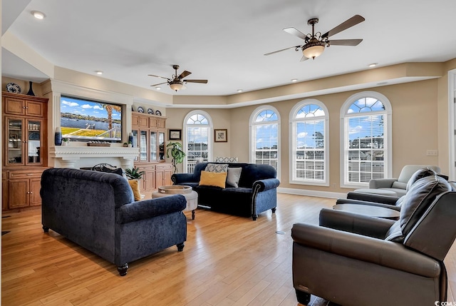 living room with ceiling fan and light wood-type flooring