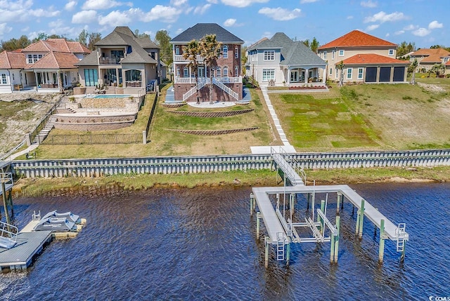 view of dock with a lawn, a water view, and a fenced in pool