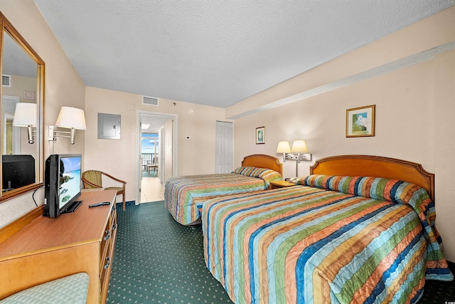 bedroom with a closet, carpet floors, and a textured ceiling