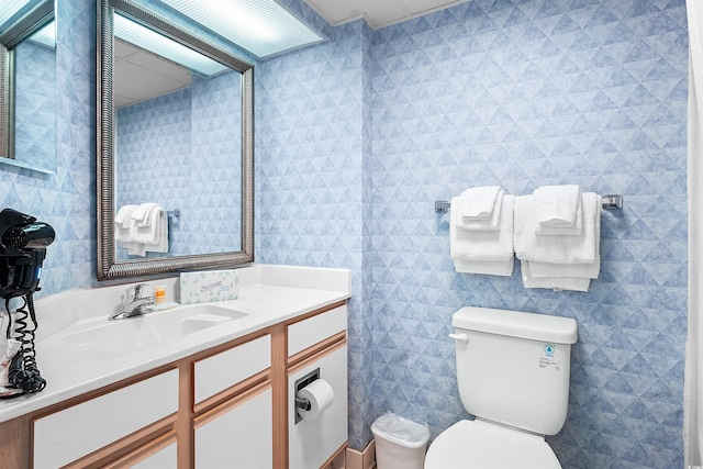 bathroom with vanity, tile walls, and toilet