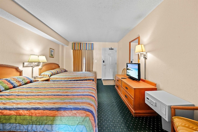 bedroom featuring a textured ceiling and dark colored carpet