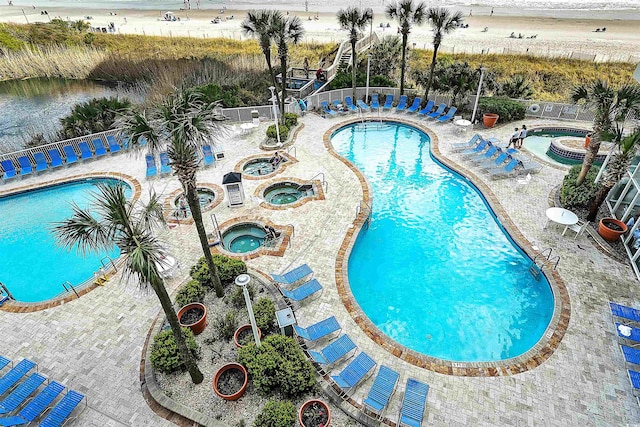 view of pool featuring a hot tub and a patio