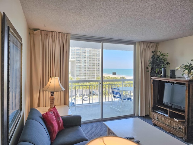 living room featuring a water view and a textured ceiling