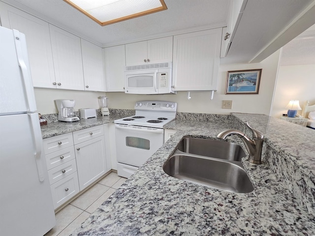 kitchen featuring white cabinets, white appliances, light stone countertops, light tile flooring, and sink