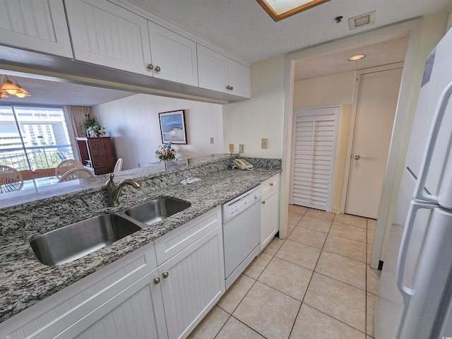 9820 Queensway Blvd Unit 501, Myrtle Beach, SC 29572 - kitchen featuring white appliances, light tile patterned flooring, white cabinets, stone counters, and a textured ceiling