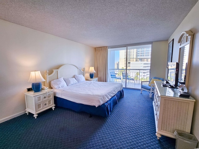 bedroom featuring access to outside, floor to ceiling windows, dark carpet, and a textured ceiling