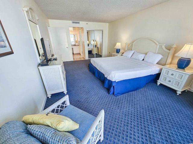 9820 Queensway Blvd Unit 501, Myrtle Beach, SC 29572 - bedroom featuring carpet floors, a textured ceiling, a closet, and connected bathroom