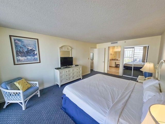 bedroom featuring carpet, a textured ceiling, and ensuite bathroom