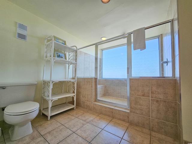 bathroom featuring a healthy amount of sunlight, toilet, and tile flooring