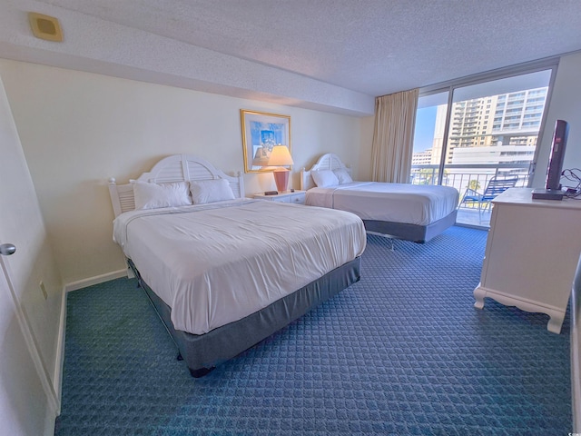 bedroom featuring a wall of windows, a textured ceiling, dark carpet, and access to outside