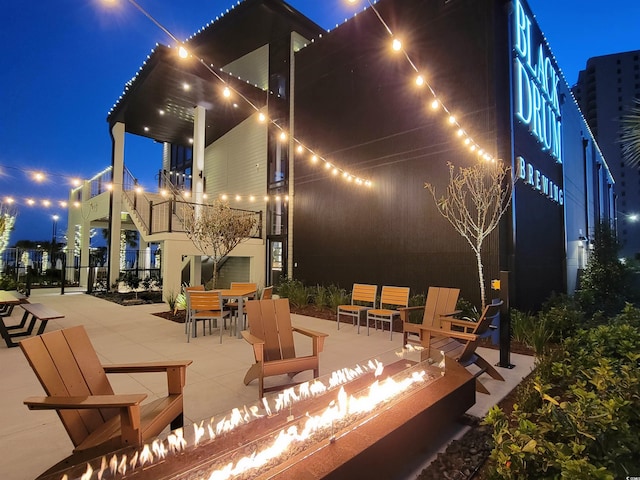 9820 Queensway Blvd Unit 501, Myrtle Beach, SC 29572 - patio at night with a fire pit, a patio area, and outdoor dining area