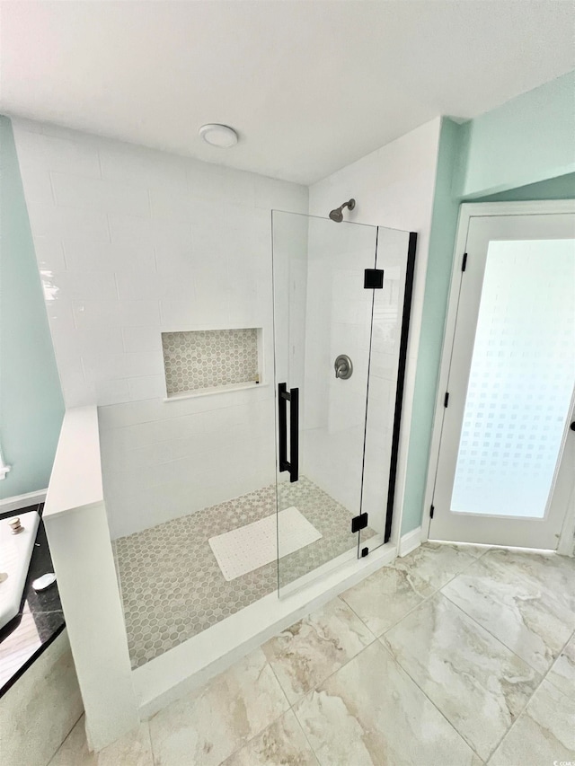 bathroom featuring a shower with shower door and tile flooring