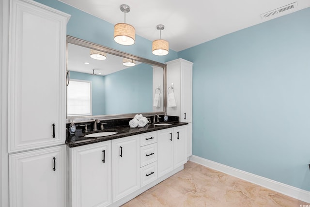 bathroom with tile floors, dual sinks, and vanity with extensive cabinet space