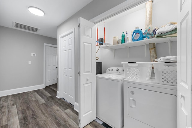 clothes washing area with dark hardwood / wood-style flooring and washer and dryer