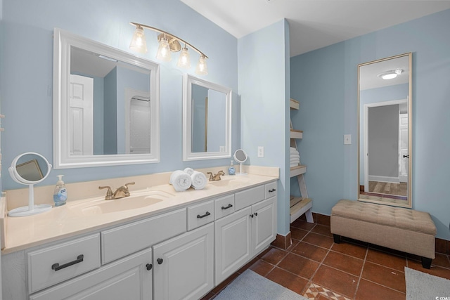 bathroom with dual sinks, large vanity, and tile flooring