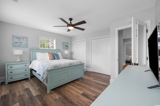 bedroom featuring dark hardwood / wood-style flooring, ceiling fan, and multiple closets