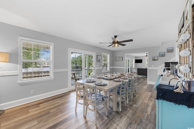 dining area featuring ceiling fan, dark wood-type flooring, a wealth of natural light, and french doors