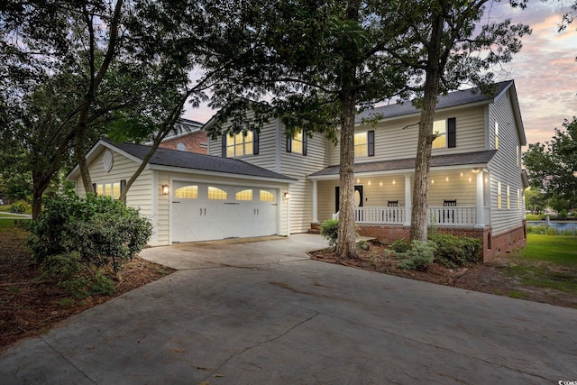 view of property featuring covered porch and a garage