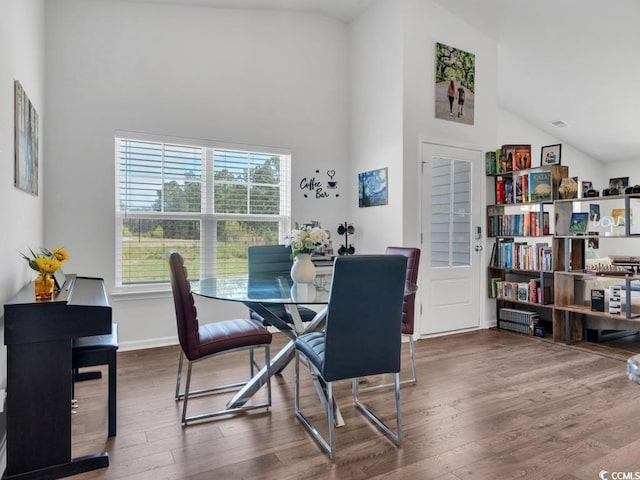 dining room featuring a wealth of natural light, dark wood-type flooring, and high vaulted ceiling