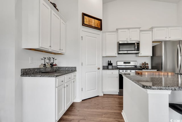 kitchen with stainless steel appliances, white cabinets, and light wood-type flooring