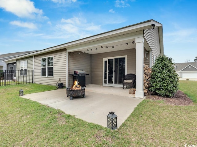 back of house featuring a patio, an outdoor fire pit, and a yard