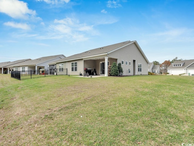 rear view of house with a patio area and a lawn