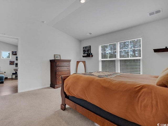 bedroom featuring lofted ceiling and light carpet