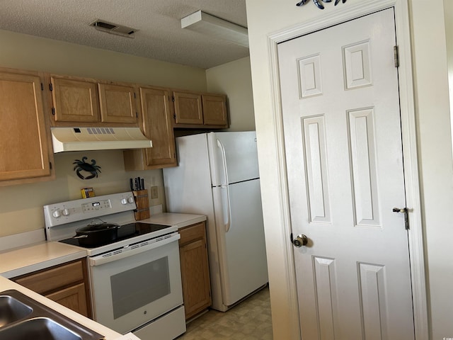 kitchen featuring a textured ceiling and white appliances