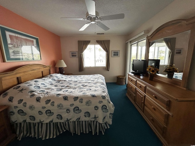 carpeted bedroom featuring ceiling fan, multiple windows, and a textured ceiling