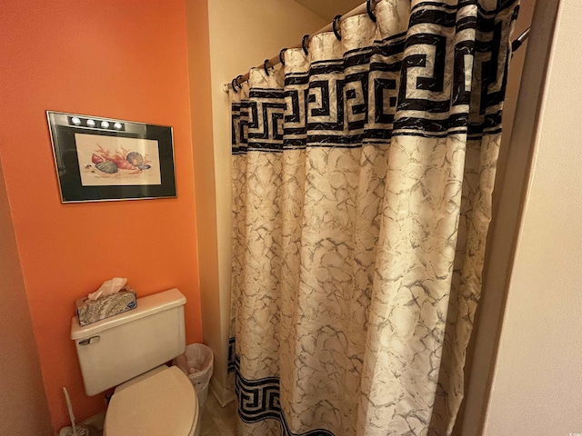 bathroom with toilet and a shower with shower curtain