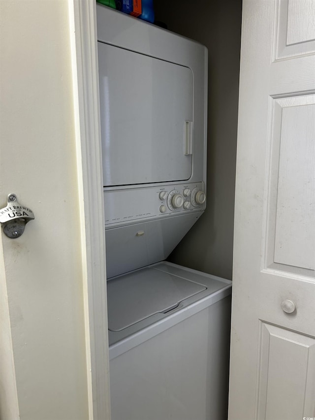 washroom featuring stacked washer and clothes dryer