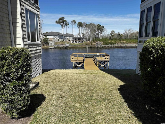 view of dock with a water view and a yard