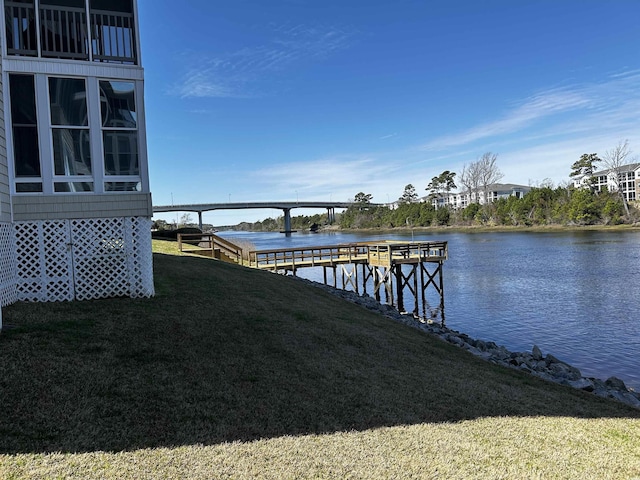 view of dock with a water view and a lawn