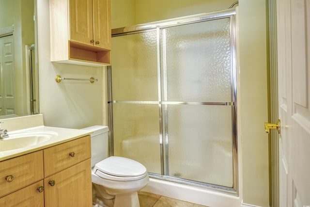 bathroom with tile patterned floors, toilet, an enclosed shower, and vanity