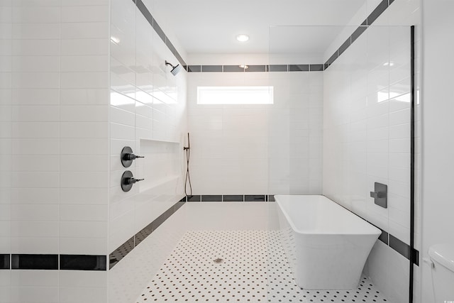 bathroom with tile flooring, tile walls, a tile shower, and toilet