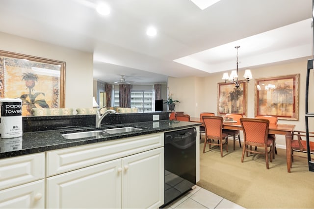 kitchen featuring ceiling fan with notable chandelier, pendant lighting, white cabinets, light carpet, and dishwasher