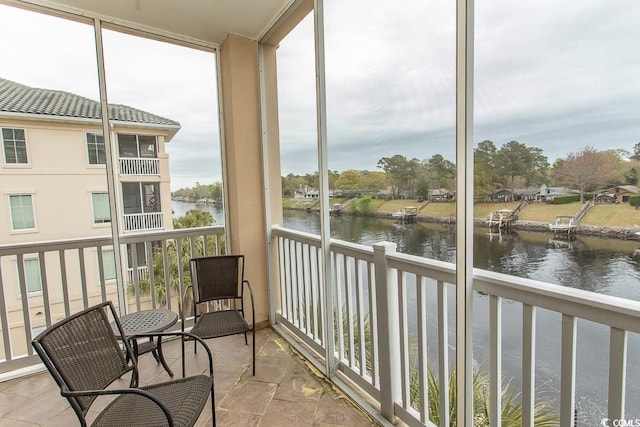 sunroom with a wealth of natural light and a water view