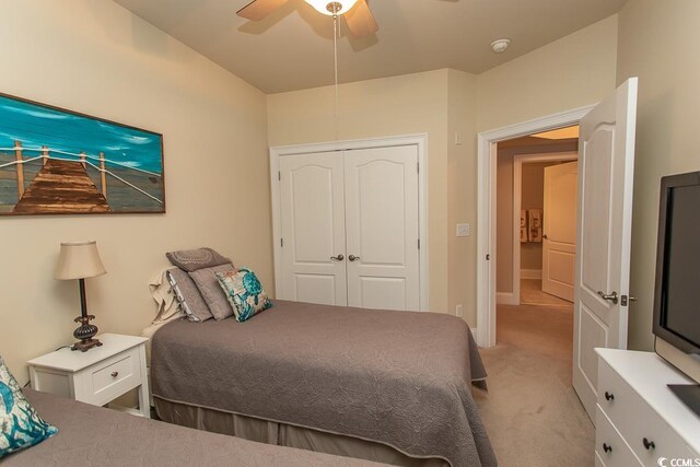 bedroom with a closet, ceiling fan, and light colored carpet