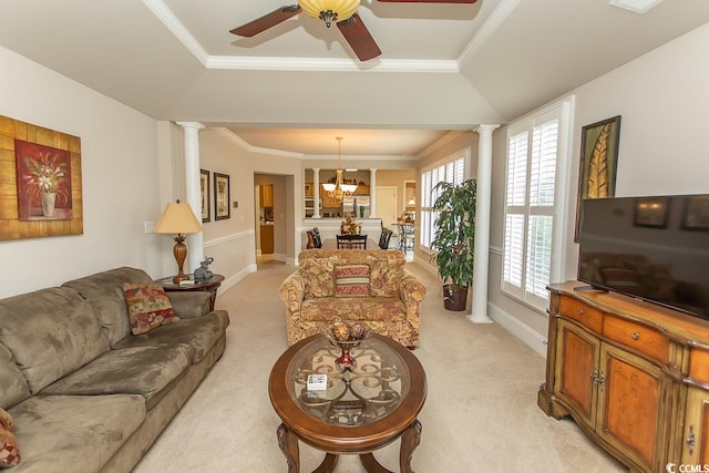 living room featuring decorative columns, light carpet, and ceiling fan with notable chandelier