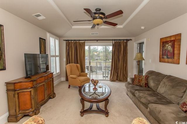 living room featuring ceiling fan, a raised ceiling, and light colored carpet