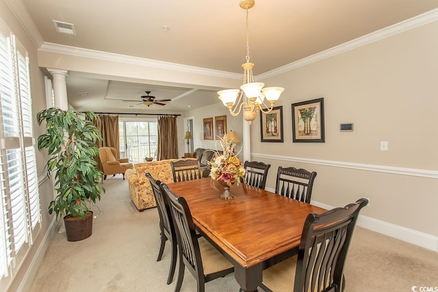 carpeted dining area featuring ceiling fan with notable chandelier, ornamental molding, decorative columns, and a raised ceiling