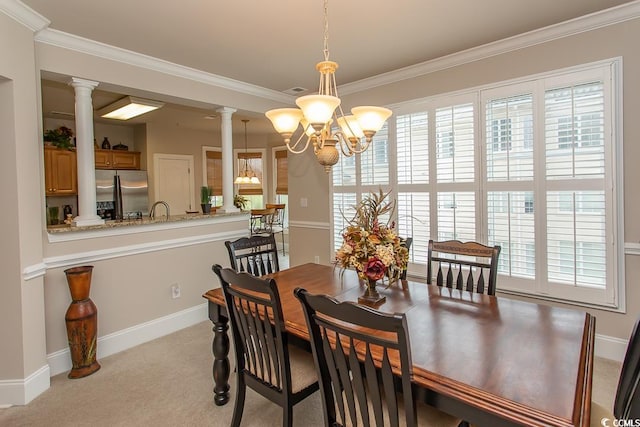 carpeted dining area with an inviting chandelier, decorative columns, and ornamental molding