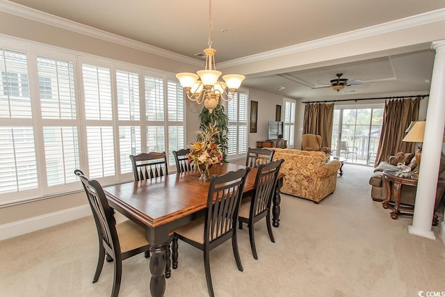 carpeted dining room featuring a raised ceiling, ornate columns, ceiling fan with notable chandelier, and ornamental molding