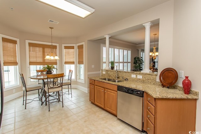 kitchen with ornate columns, stainless steel dishwasher, a notable chandelier, light stone countertops, and sink