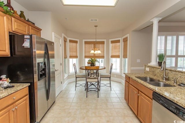 kitchen with a chandelier, light stone countertops, appliances with stainless steel finishes, sink, and ornate columns