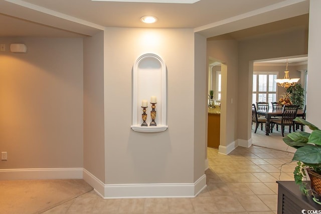 corridor featuring a notable chandelier and light tile floors