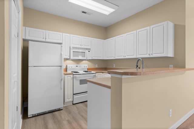 kitchen with kitchen peninsula, white appliances, light hardwood / wood-style floors, white cabinetry, and sink